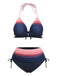 Ein zweiteiliges Bikini-Set mit einem Farbverlauf von Rosa zu Marineblau, bestehend aus einem Neckholder-Oberteil mit Rüschenbesatz und einem hochgeschnittenen Höschen mit seitlichen Bindebändern.