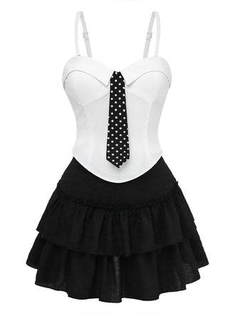 Weißes Oberteil mit schwarzer gepunkteter Krawatte und schwarzem Rüschenrock auf weißem Hintergrund