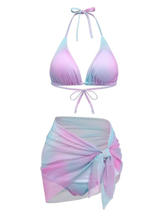 Ein dreiteiliges Bademodenset bestehend aus einem Triangel-Neckholder-Bikini-Oberteil, passendem Höschen und einem transparenten, vorne zu bindenden Netz-Sarong in einem blauen, rosa und violetten Ombré-Muster.