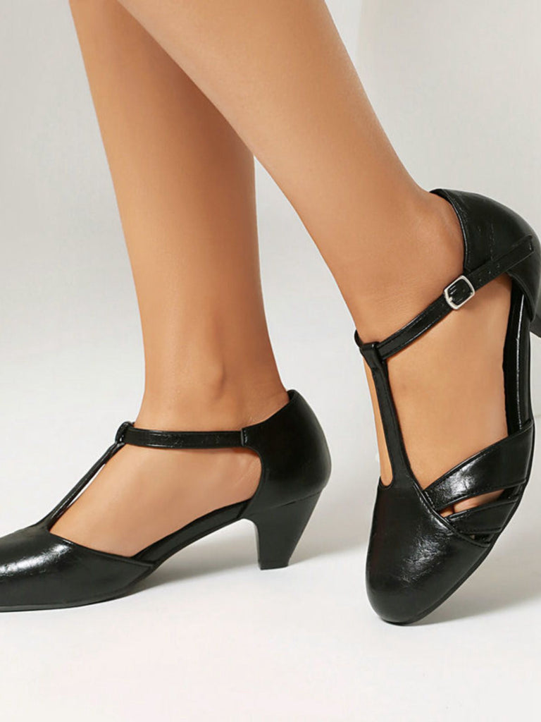 Schwarze High Heels, getragen mit beigen Strümpfen vor hellem Hintergrund