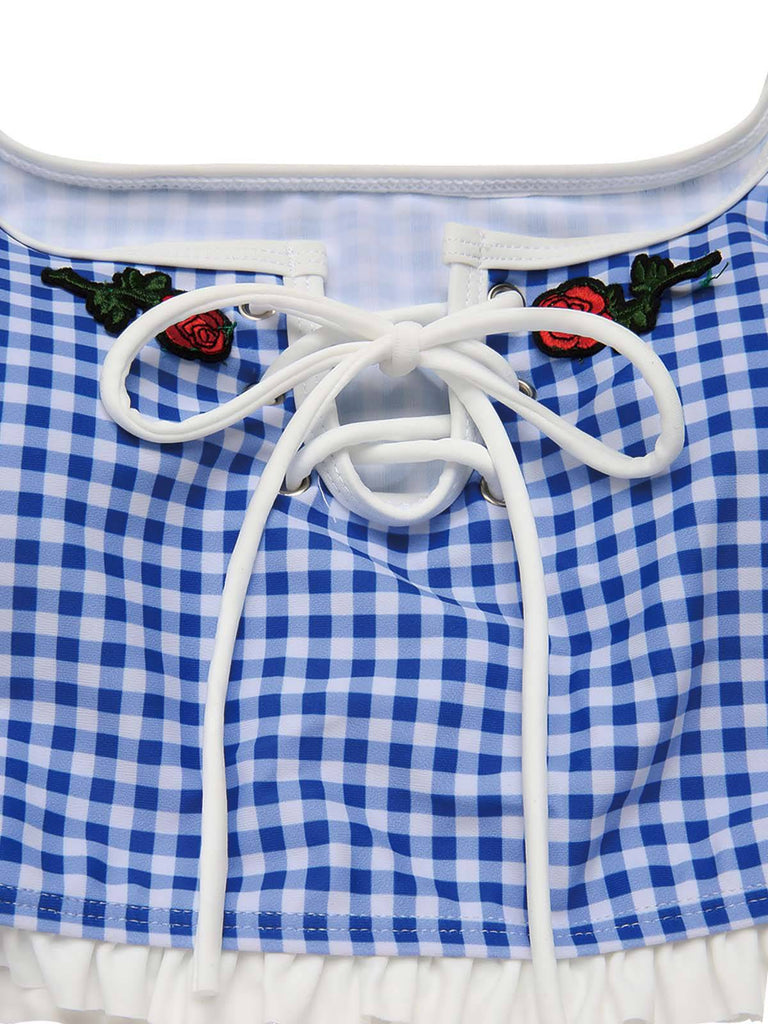 Blau-weiß kariertes Kleid mit weißer Spitzenborte und gestickten Rosen.