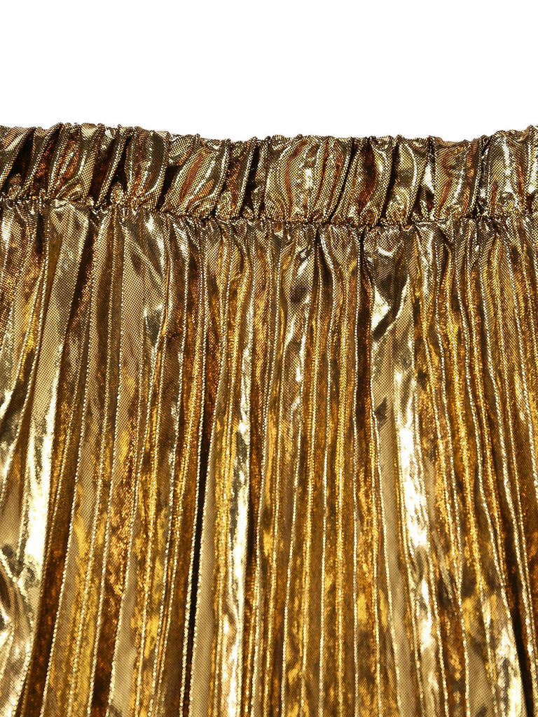 Nahaufnahme eines goldfarbenen, metallisch glänzenden Faltenrocks vor weißem Hintergrund