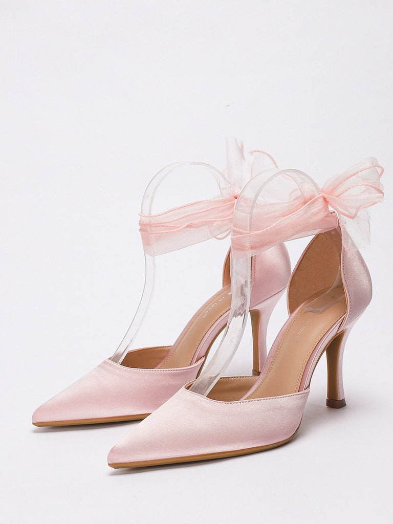 Rosafarbene High Heels mit transparentem Band auf hellgrauem Hintergrund