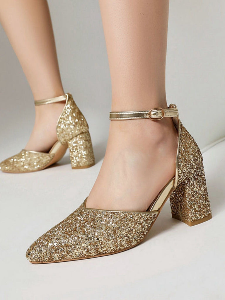 Goldglitzernde High Heels auf neutralem Hintergrund