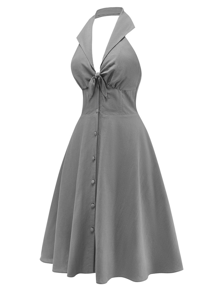 Graues Neckholderkleid mit V-Ausschnitt, Seitenansicht, die eine schmeichelhafte Silhouette und ein elegantes Ausschnittdesign zeigt.