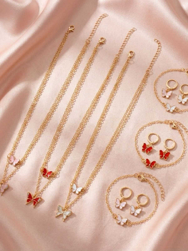 Goldschmuckset mit Halsketten und Ohrringen auf rosa Satinhintergrund