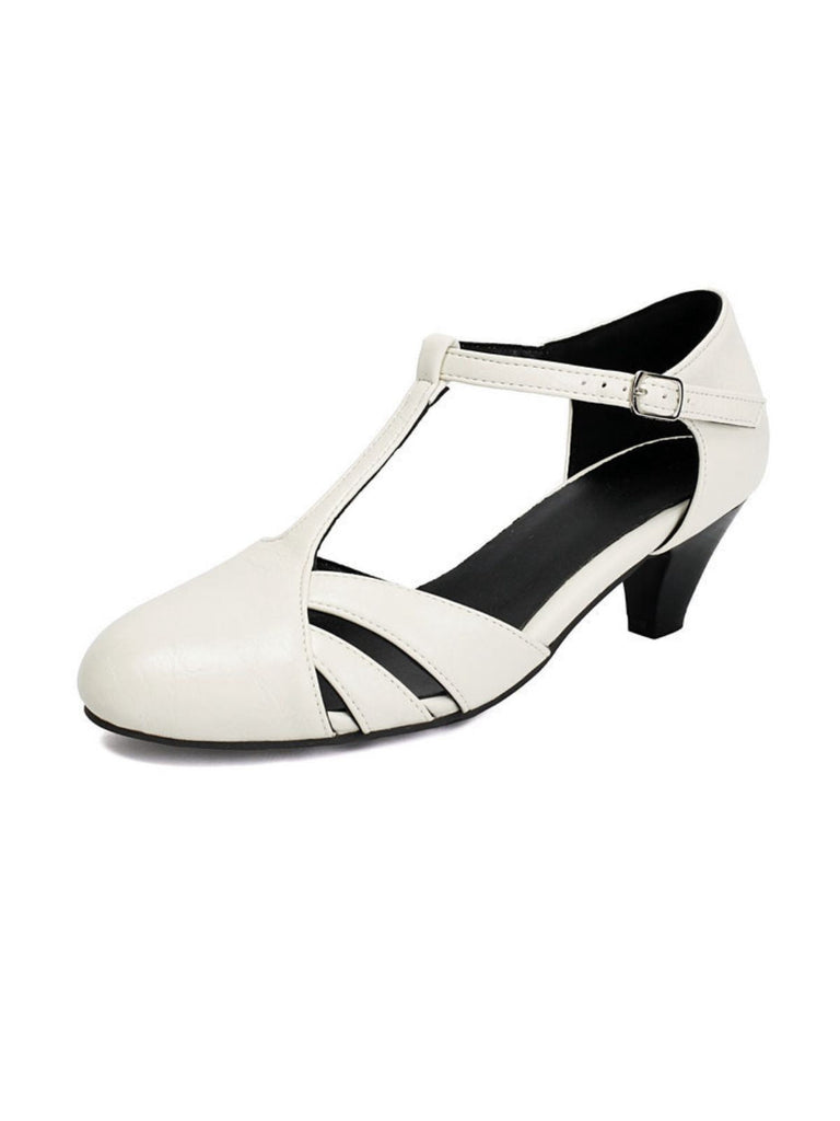 Klassische, geschlossene T-Riemchen-Pumps im Vintage-Stil, mittelhoher Absatzhöhe und seitlichen Cut-outs – ideal fürs Büro und besondere Anlässe.