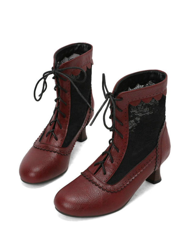 Ein Paar rote Stiefeletten mit schwarzen Schnürsenkeln auf weißem Hintergrund