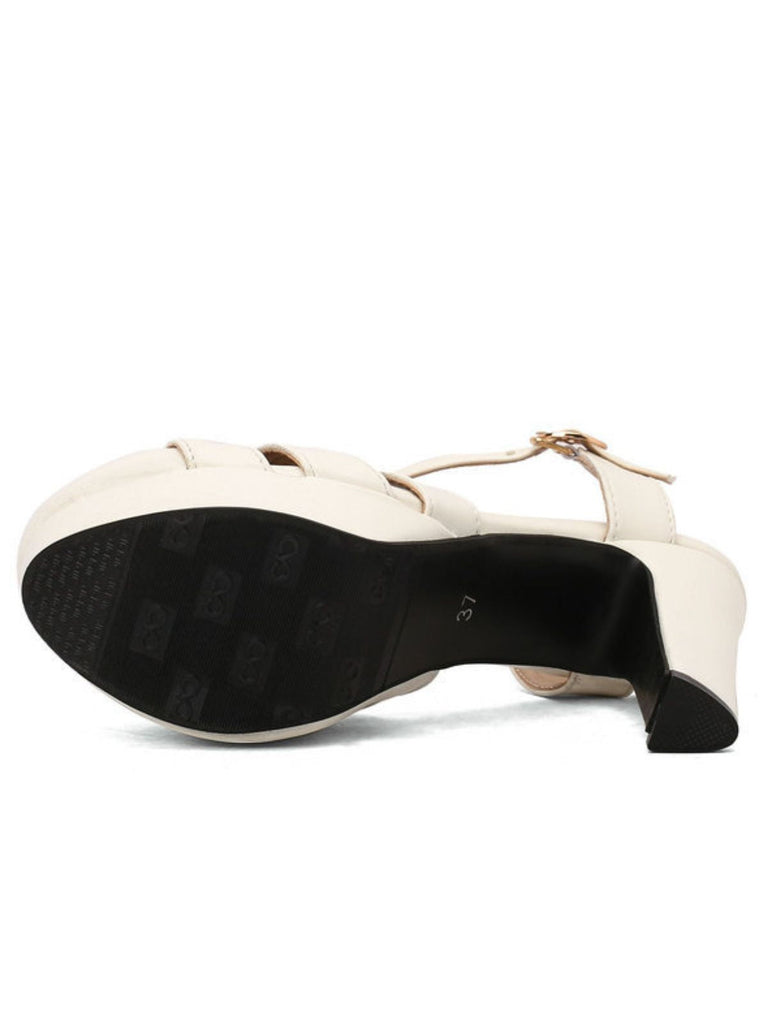 Ansicht der rutschfesten schwarzen Gummisohle an der Unterseite der weißen Plateau-Sandalen mit hohem Absatz.