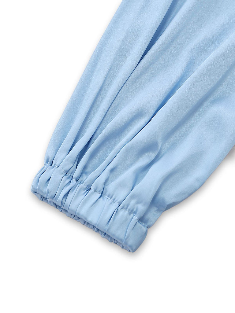 Detailaufnahme des voluminösen Ballonärmels und seines gerafften elastischen Bündchens am seidigen Lounge-Top.