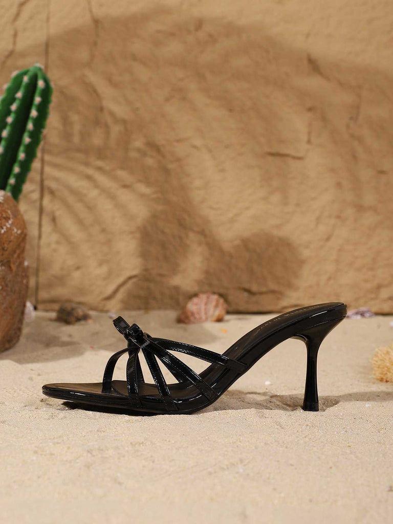 Schräge Ansicht eines einzelnen schwarzen, geknoteten Maultiers mit Riemen auf Sand.