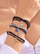 Mehrere Armbänder mit Anhängern an einem Handgelenk vor hellem Hintergrund