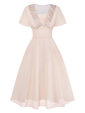 Zartrosa Kleid mit Spitzendetails auf weißem Hintergrund