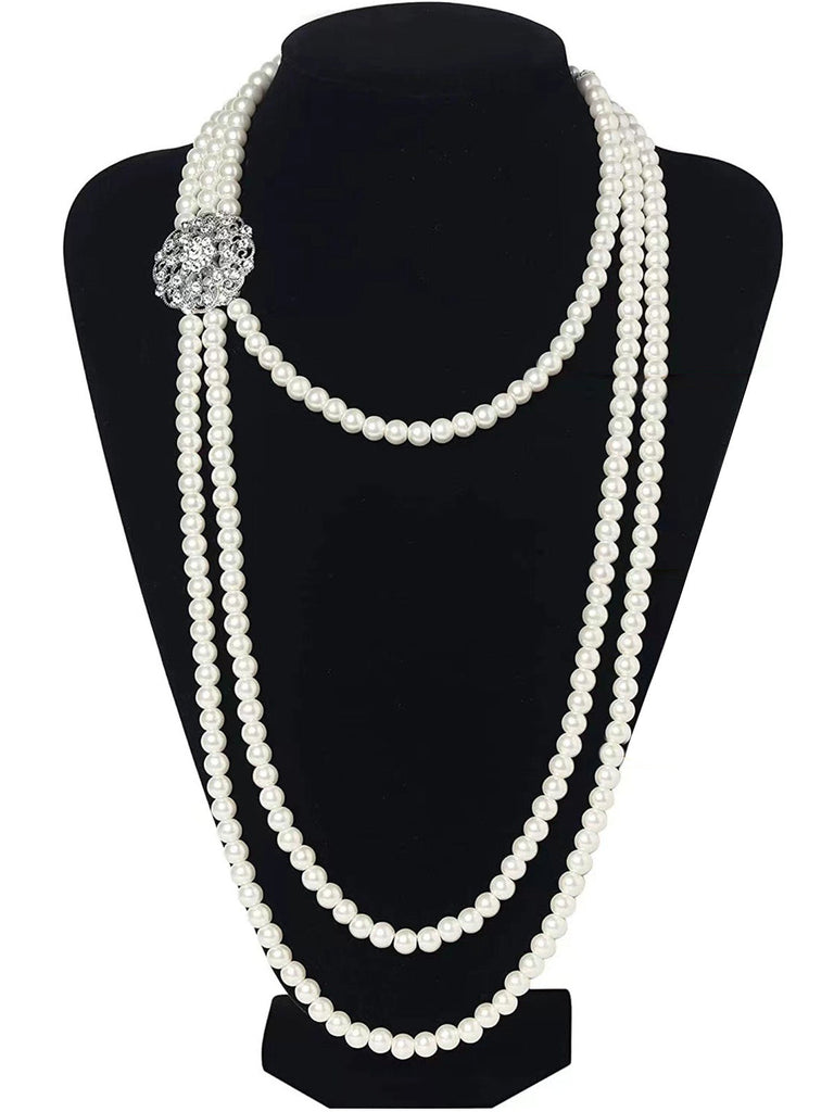Eine lange, mehrsträngige Perlenkette im Stil von „Der große Gatsby“, die an einer schwarzen Schaufensterpuppe präsentiert wird und ihren eleganten Fall hervorhebt.