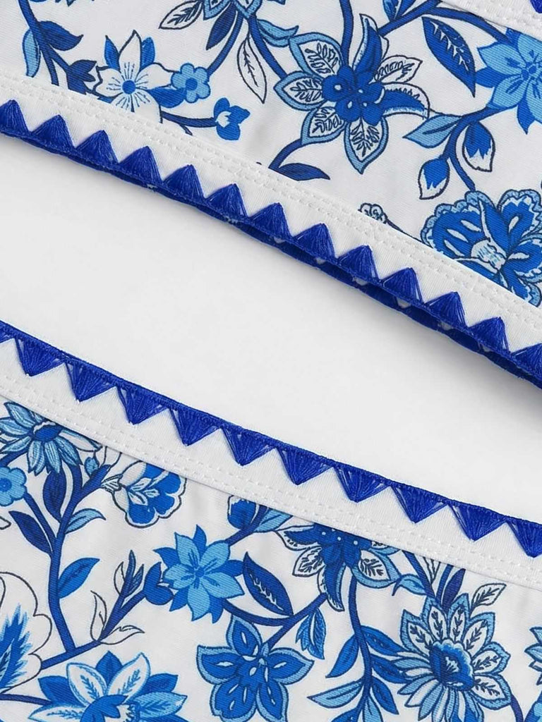 Makroaufnahme des marineblauen, gewellten Besatzes am Bund und Saum des geblümten Bikinis.