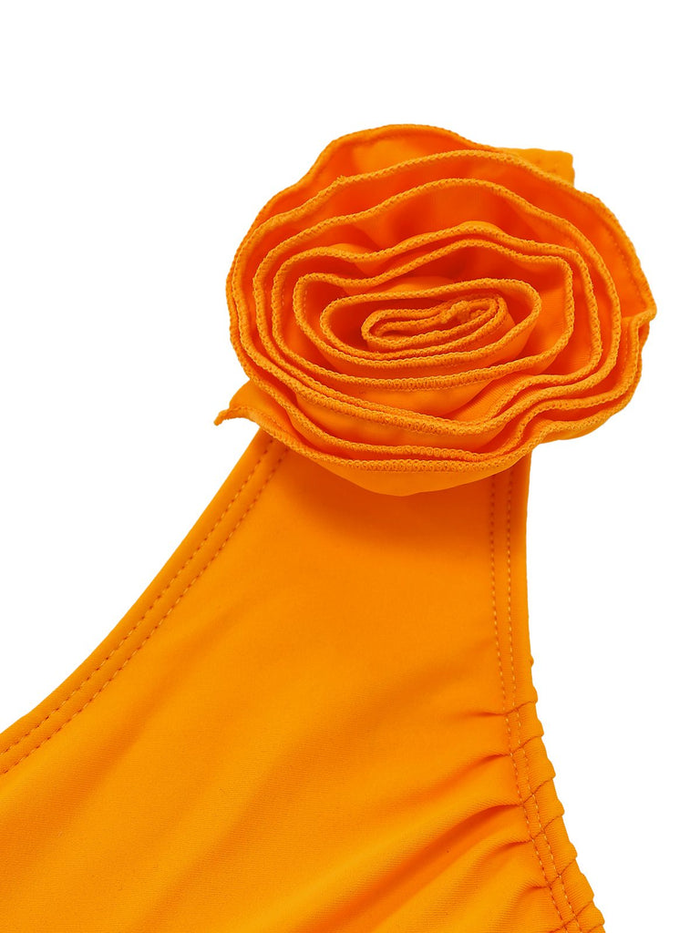 Orangefarbenes Bikini-Oberteil mit Blumenmuster auf weißem Hintergrund