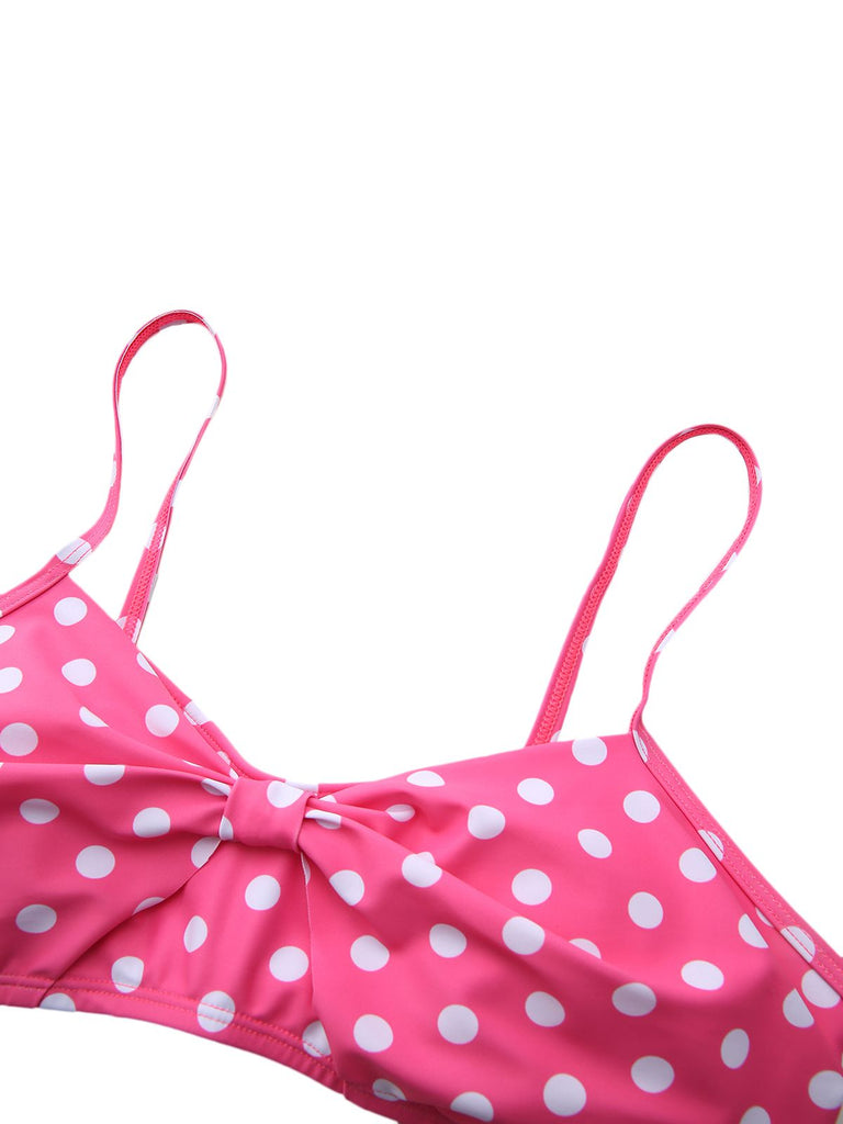 Nahaufnahme des pink-weiß gepunkteten Bikini-Oberteils, die die zentrale Schleife und die verstellbaren Träger zeigt.