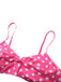 Nahaufnahme des pink-weiß gepunkteten Bikini-Oberteils, die die zentrale Schleife und die verstellbaren Träger zeigt.