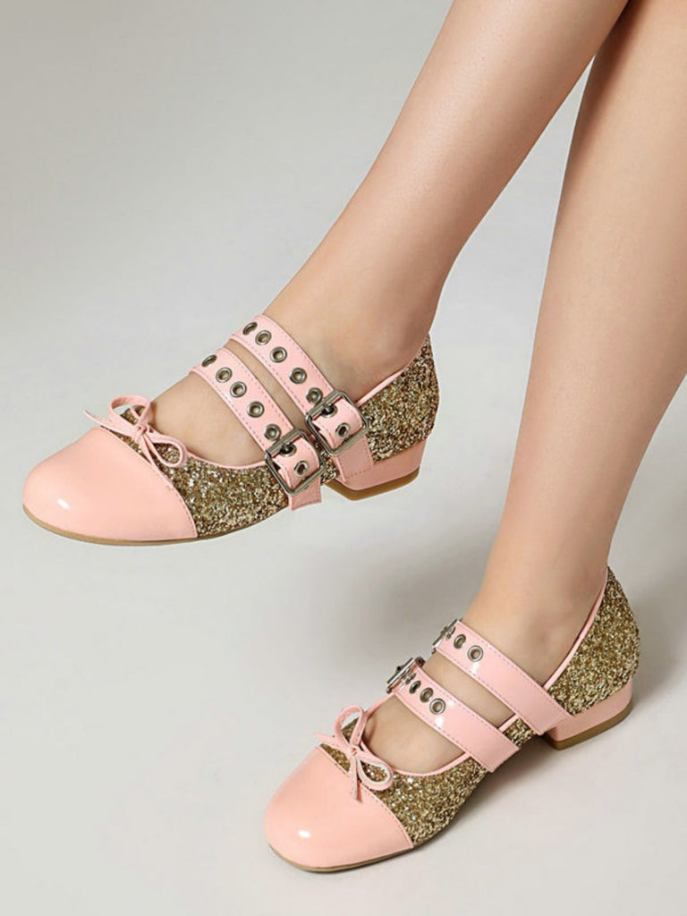 Rosa-goldene Schuhe mit Zierriemen auf neutralem Hintergrund