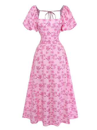 Studioansicht von vorne auf das rosa geblümte Midikleid, das die taillierte Passform und den ausgestellten Rock betont.