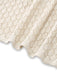 Eine Nahaufnahme, die den Saum und die detaillierte Strickarbeit des cremefarbenen Häkel-Überwurfs zeigt.