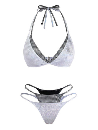 Ein zweiteiliges, silberfarbenes, schillerndes Bikini-Set mit Neckholder-Oberteil und Höschen mit doppelten Trägern und schwarzem Netzbesatz.