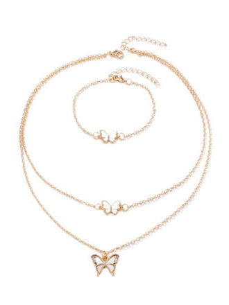 Goldene Schmetterlingskette und Armband auf weißem Hintergrund