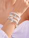 Nahaufnahme eines Handgelenks mit mehreren weißen Perlenarmbändern mit silbernen Ankeranhängern.